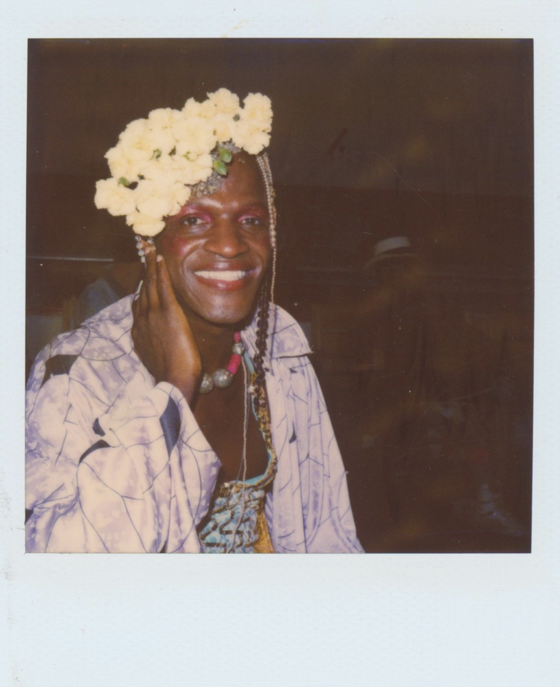 Download the full-sized image of A Photograph of Marsha P. Johnson Smiling and Wearing a Patterned Purple Jacket