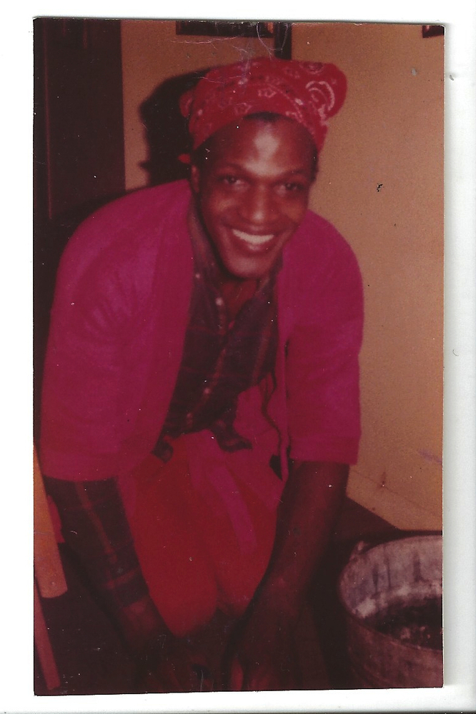 Download the full-sized image of A Photograph of Marsha P. Johnson Cleaning and Wearing an All Red Outfit