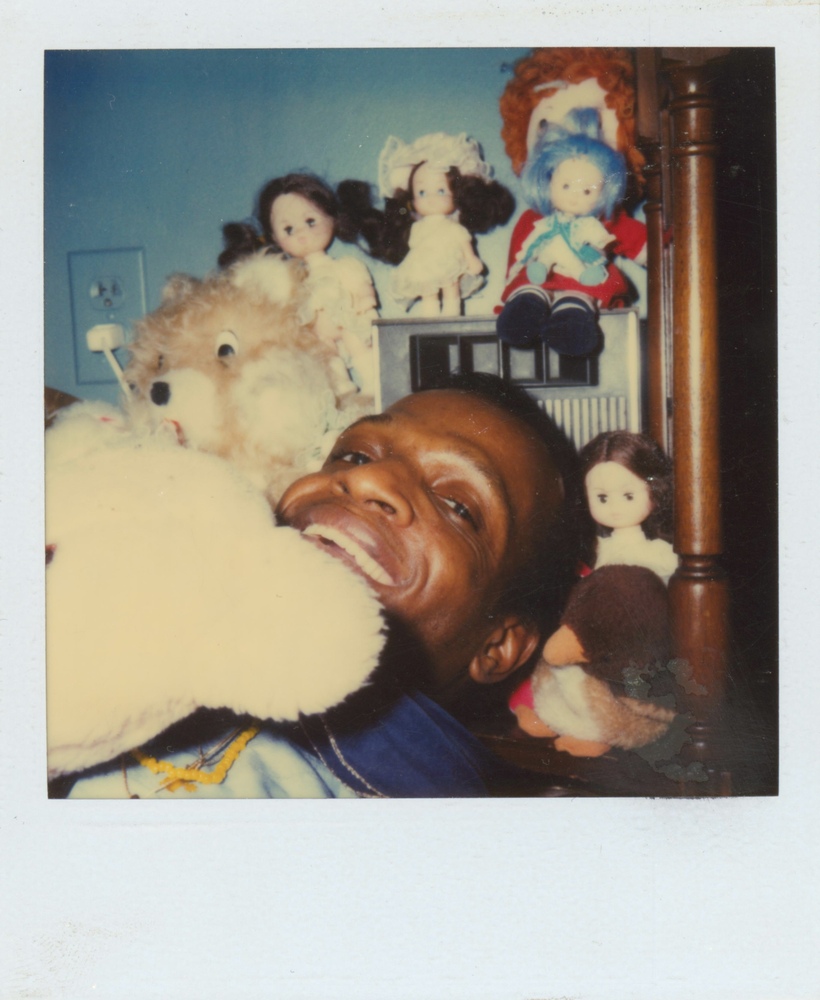 Download the full-sized image of A Photograph of Marsha P. Johnson Smiling With Dolls and Stuffed Animals