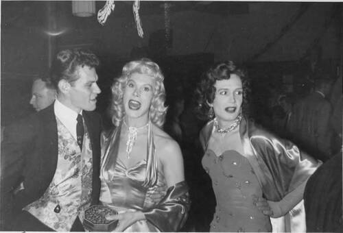 Download the full-sized image of Two femmes posing with a man at a party