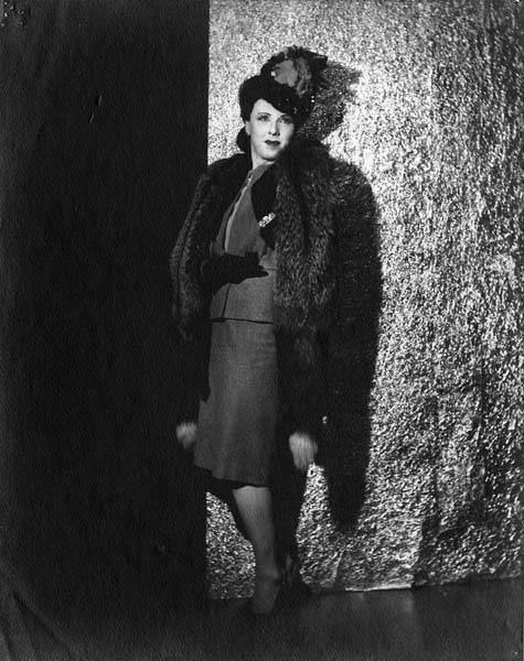 Download the full-sized image of Jackie Starr posing against a wall in suit and fur