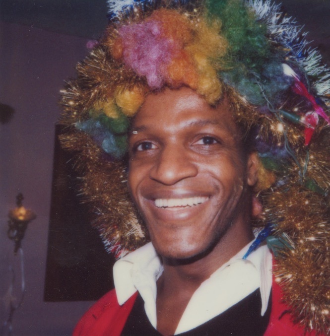 Download the full-sized image of A Photograph of Marsha P. Johnson Wearing a Rainbow Wig and Smiling at the Camera