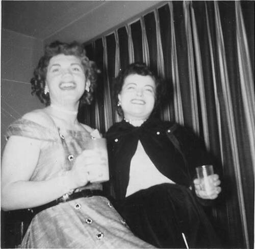 Download the full-sized image of Two unknown femmes smiling and holding glasses