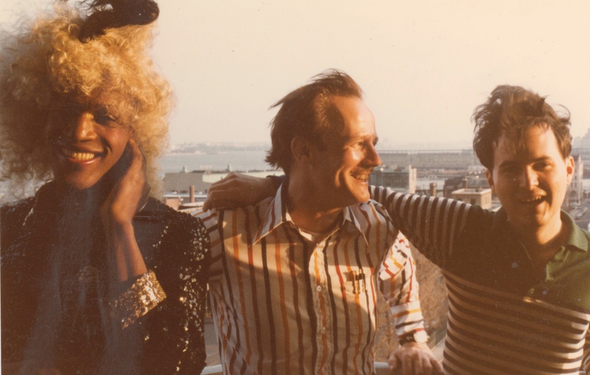 Download the full-sized image of A Photograph of Marsha P. Johnson with Curly Blonde Hair and a Black Sequined Jacket, Posing with Randy Wicker and Another Person