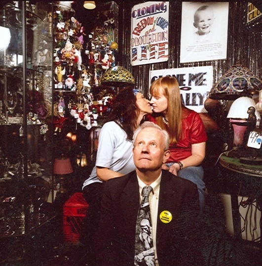 Download the full-sized image of A Photograph of Sylvia Rivera Leaning In to Kiss Her Partner Julia Murray, Randy Wicker Sits in Front of Them