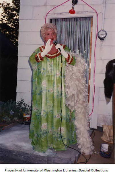 Download the full-sized image of Countess Estelle performing in a green dress in a backyard