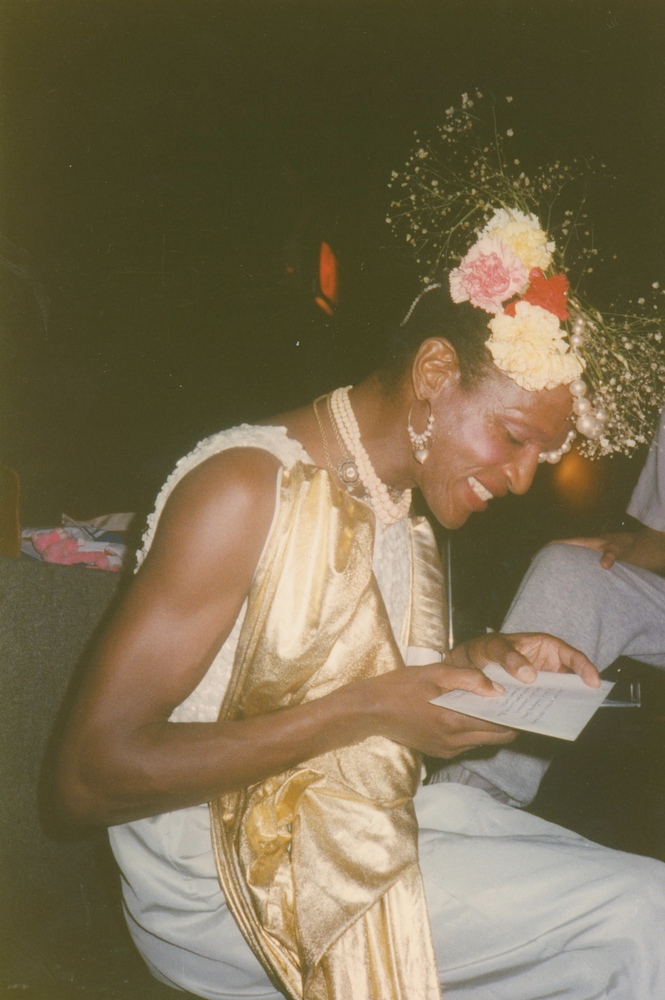 Download the full-sized image of A Photograph of Marsha P. Johnson Reading a Letter at Her Birthday Party