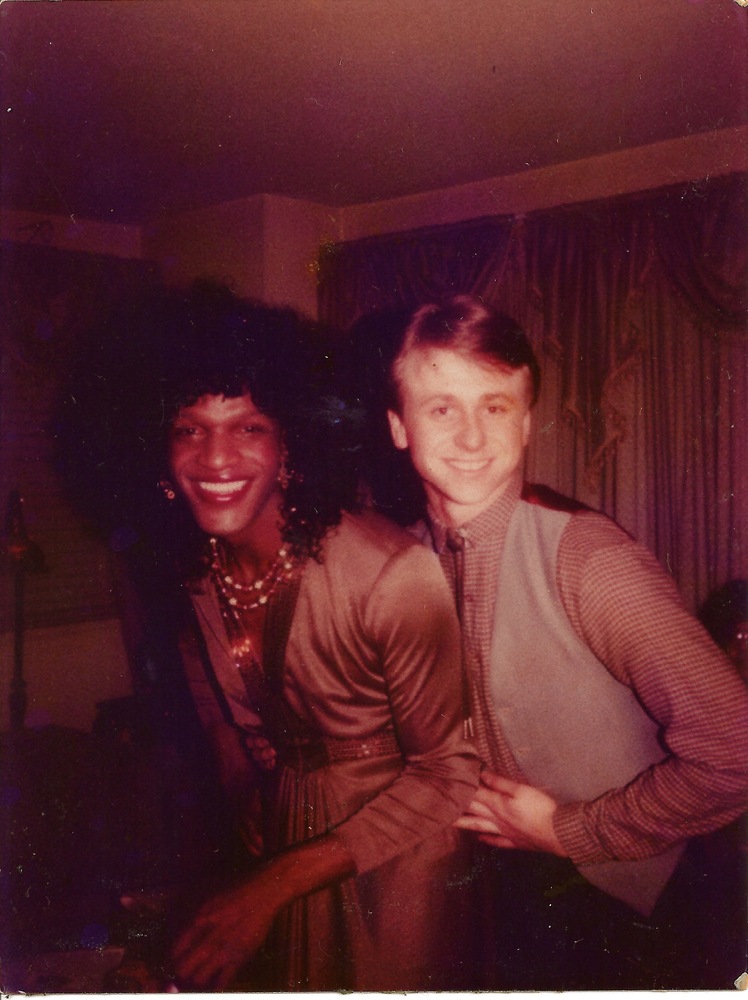 Download the full-sized image of A Photograph of Marsha P. Johnson Wearing a Formal Brown Long Sleeve Dress Posing with Roommate