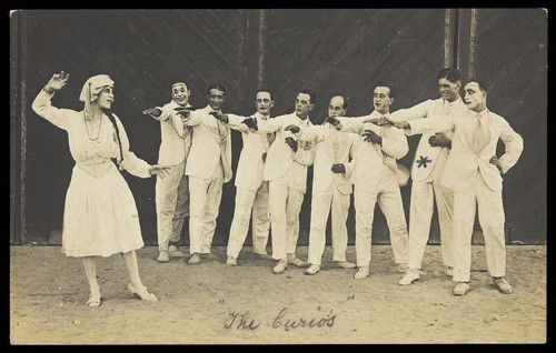 Download the full-sized image of Actors, one in drag, performing on stage as "The Curios". Photographic postcard, ca. 1918-1920.